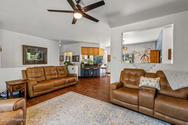 a living room with furniture and a view of kitchen