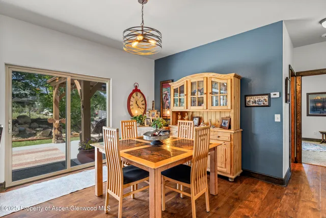 a dining room with furniture a chandelier and wooden floor