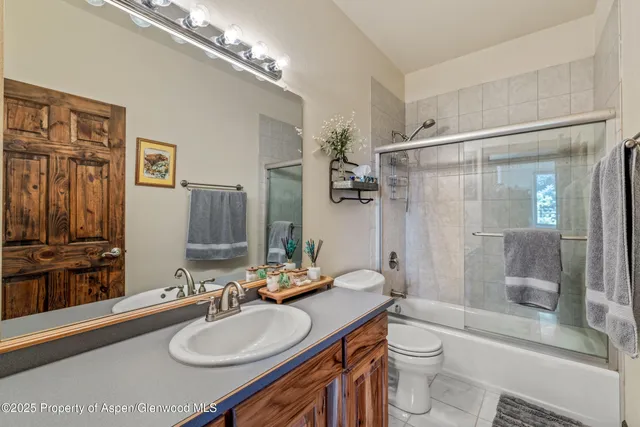 a bedroom with a bed a ceiling fan and a dresser