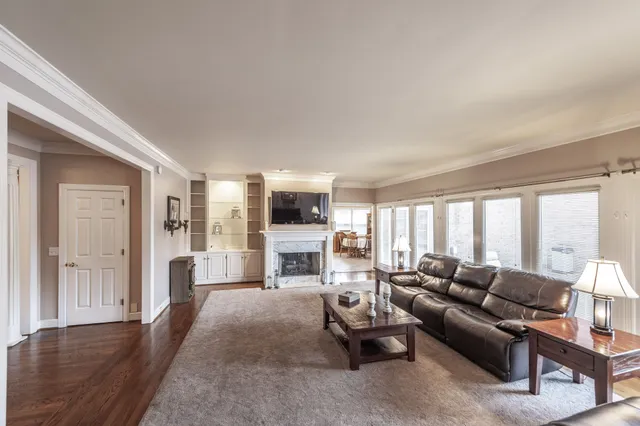 a living room with furniture a large window and a chandelier