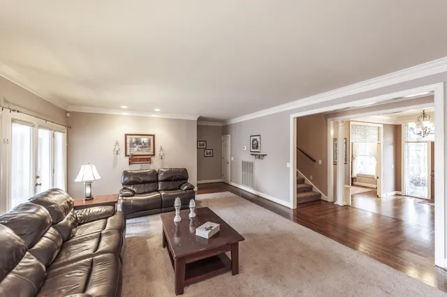 a kitchen with stainless steel appliances granite countertop a sink dishwasher a stove and a dining table with wooden floor