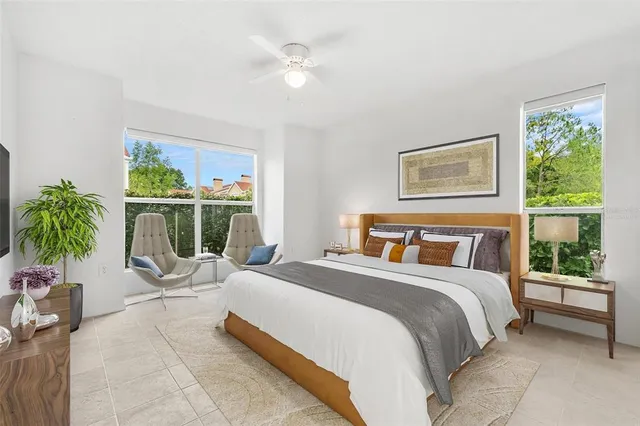 a bedroom with a balcony a bed a potted plant and a large window
