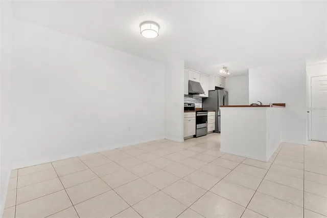a view of a kitchen with refrigerator and white cabinets