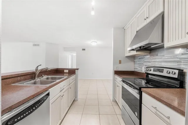 a kitchen with granite countertop a sink stove and cabinets