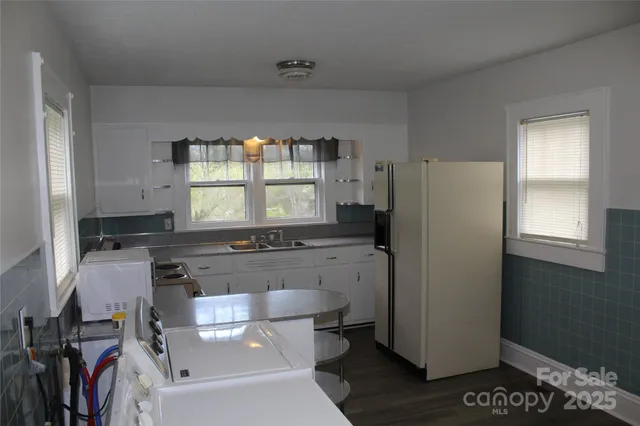 a kitchen with a refrigerator and a stove top oven