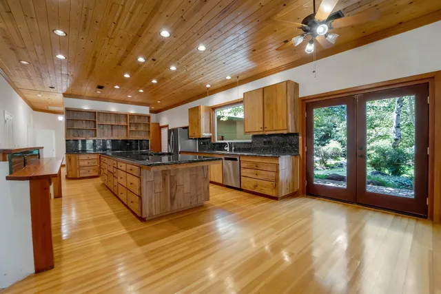 a kitchen with stainless steel appliances granite countertop a stove a sink and a refrigerator