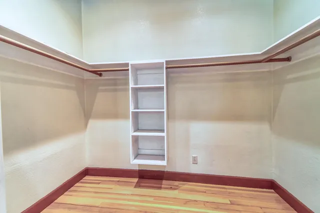 a view of a room with wooden floor and fan