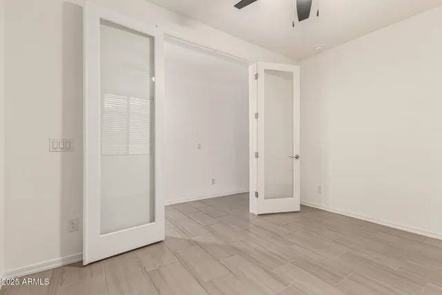 a bed sitting in a bedroom next to a window and a chandelier