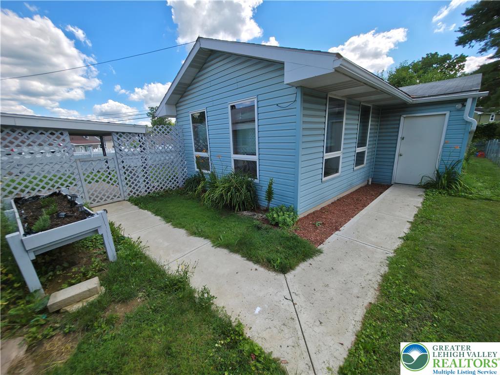 719 Keystone Avenue Bethlehem, PA 18018 - Photo 32 of 32 A quaint blue siding cottage with a charming lattice fence, offering a serene outdoor space.