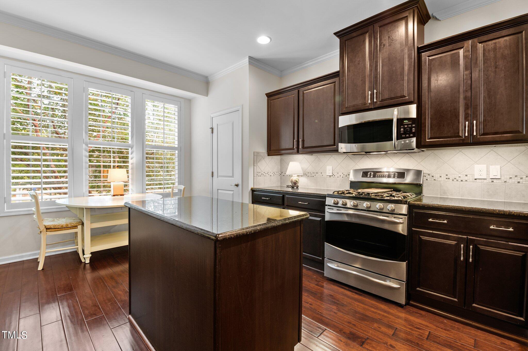 5657 Wade Park Boulevard Raleigh, NC 27607 - Photo 5 of 24 a kitchen with stainless steel appliances a stove a sink and microwave