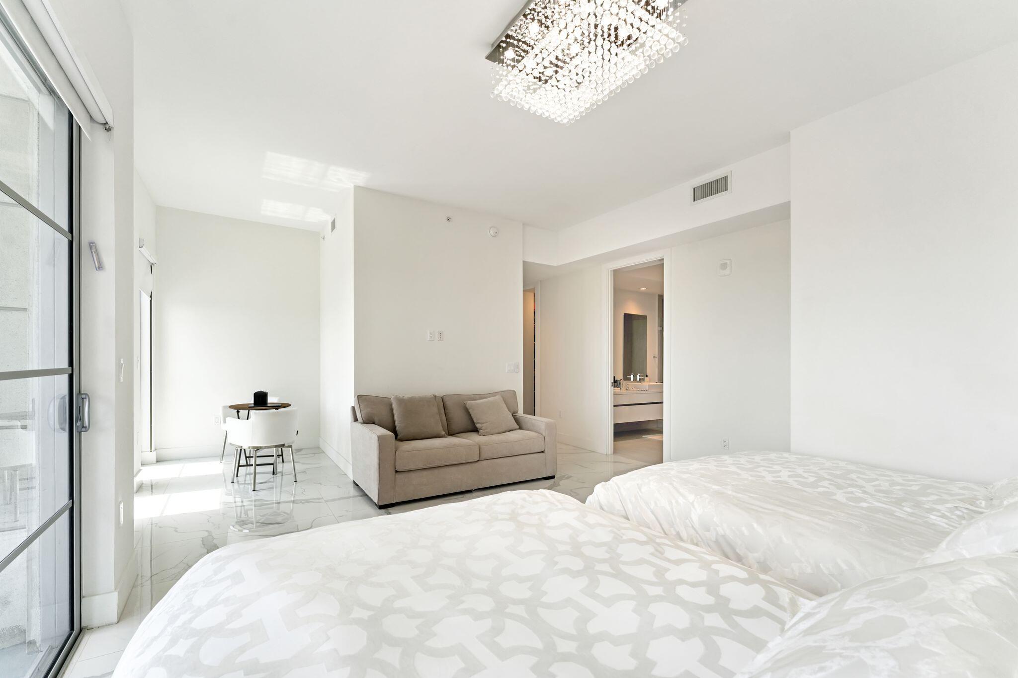 155 East Boca Raton Road, Unit 603 Boca Raton, FL 33432 - Photo 19 of 55 a bedroom with a large bed and a chandelier