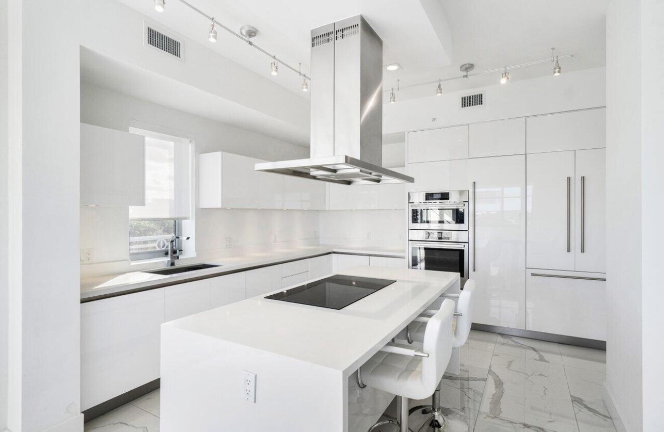 155 East Boca Raton Road, Unit 603 Boca Raton, FL 33432 - Photo 8 of 55 a kitchen with a sink a stove and chairs