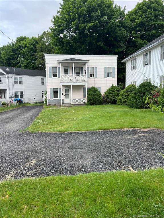 a front view of a house with a yard and trees