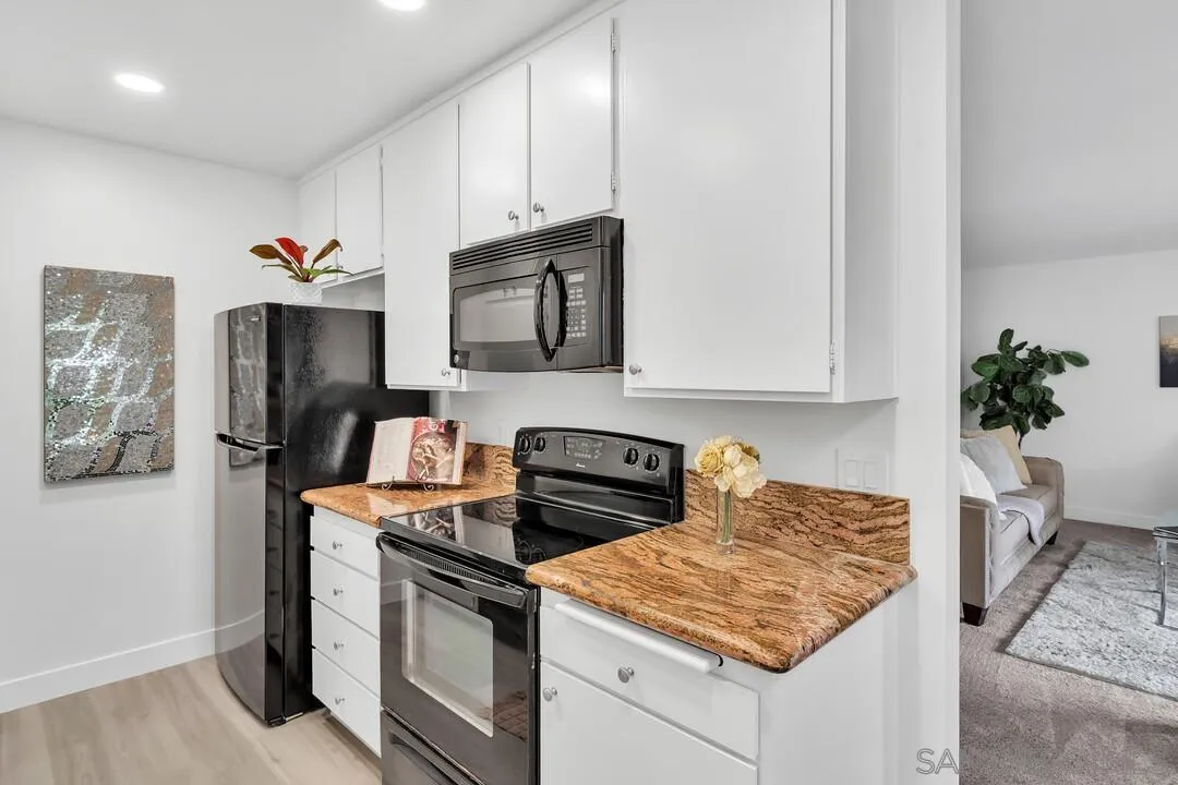 8524 Via Mallorca, Unit C La Jolla, CA 92037 - Photo 10 of 36 a kitchen with stainless steel appliances granite countertop a stove a sink and a microwave