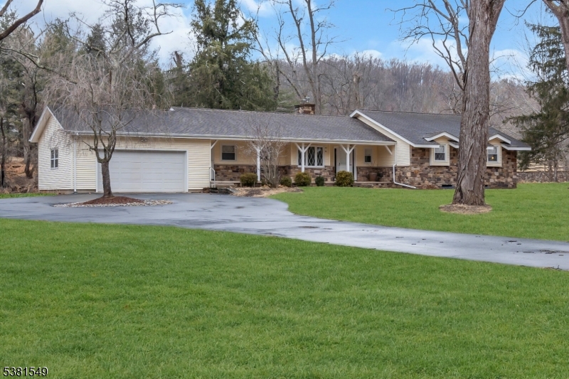 a front view of a house with a garden and trees