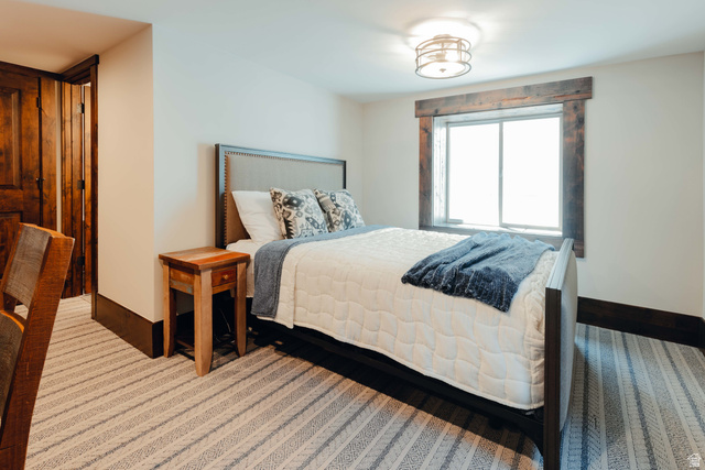 1667 West Tollgate Cyn Road Coalville, UT 84017 - Photo 40 of 61 Bedroom featuring a window with rustic wood trim, a contemporary ceiling fixture, and patterned carpet flooring