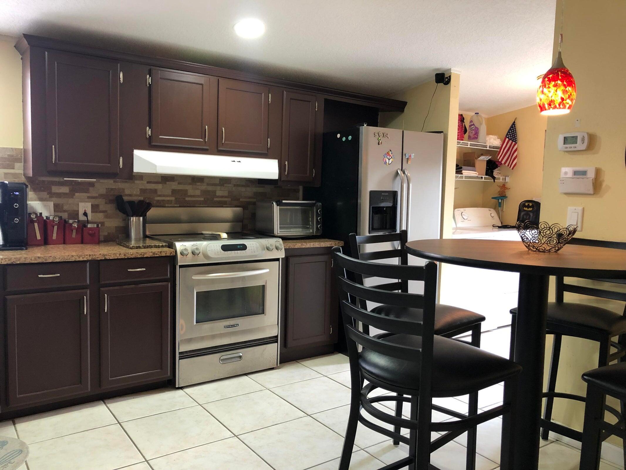 11945 Flotilla Place Boca Raton, FL 33428 - Photo 3 of 17 a kitchen with a wooden table and chairs