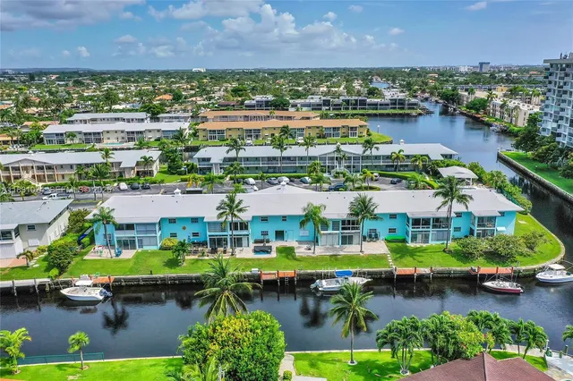 an aerial view of houses and yard with swimming pool and outdoor seating