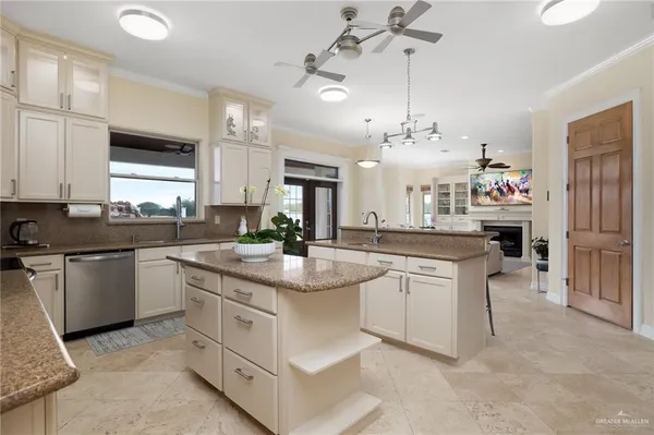 a kitchen with kitchen island granite countertop a sink cabinets and stainless steel appliances