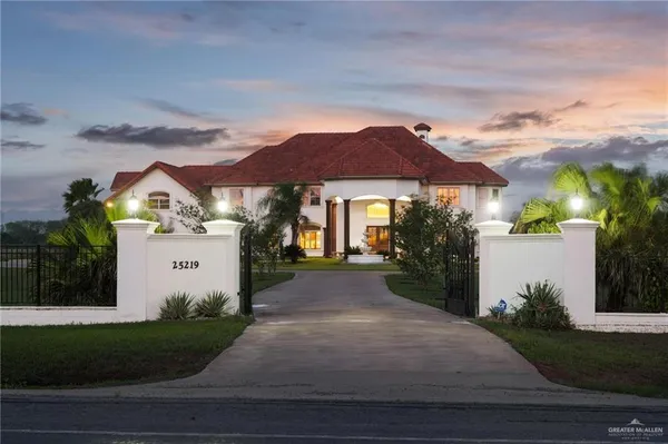 a front view of a house with yard and parking
