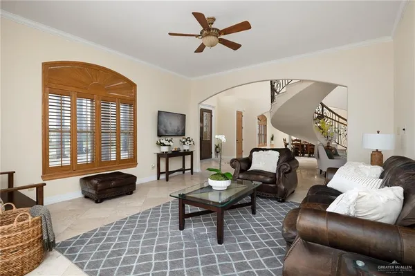 a living room with furniture kitchen view and a chandelier