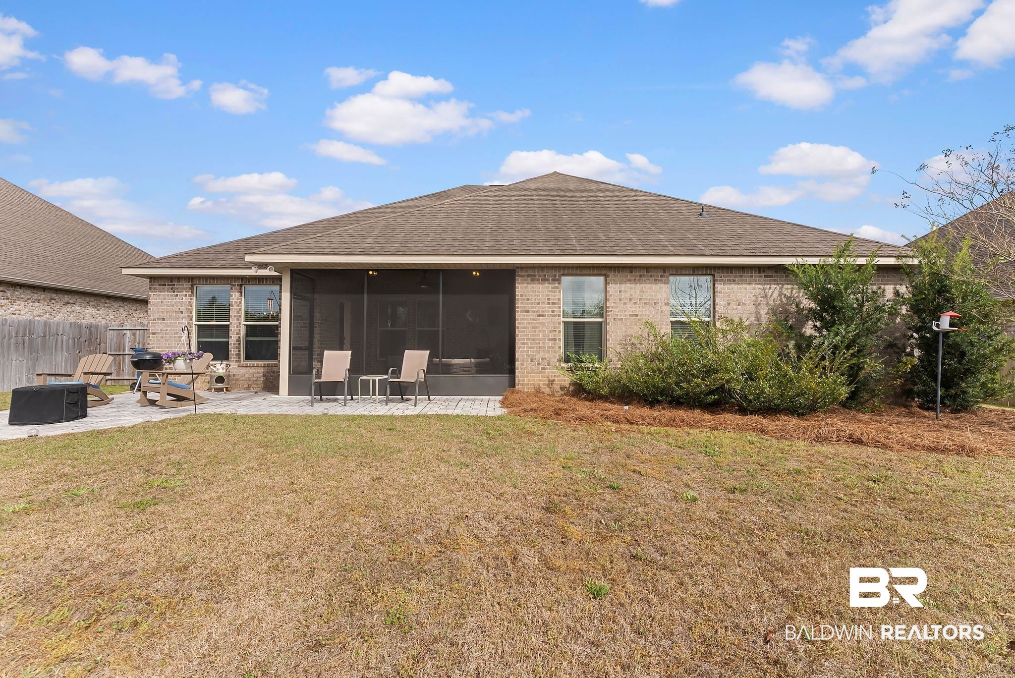 7015 Rocky Rd Loop Gulf Shores, AL 36542 - Photo 38 of 41 Rear view of property with a sunroom, brick siding, a patio area, and a shingled roof