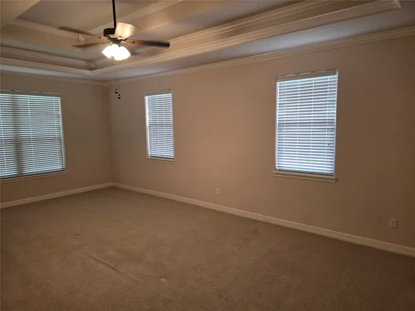 en empty room with windows and ceiling fan