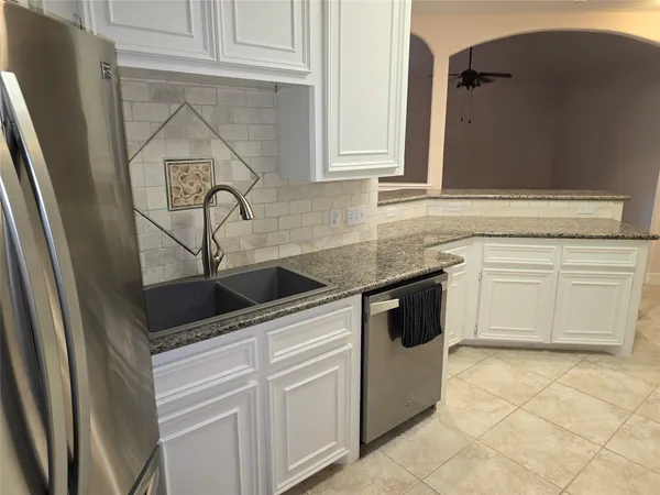 a kitchen with white cabinets and white appliances