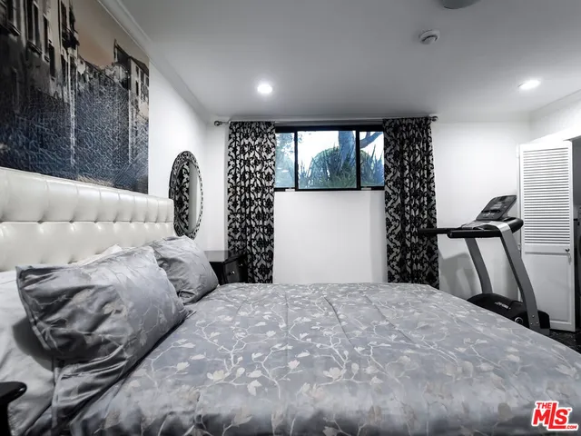 a bedroom with a bed and a large window