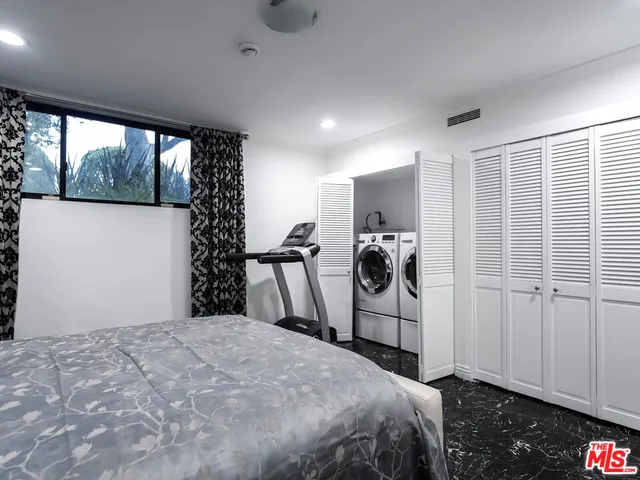 a utility room with dryer washer and a view of living room