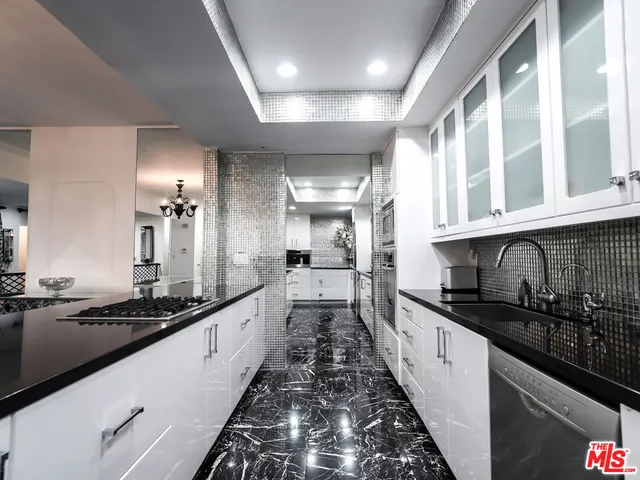 a large kitchen with granite countertop lots of counter space and a sink