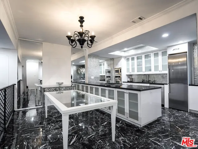 a kitchen with stainless steel appliances granite countertop a sink and a refrigerator