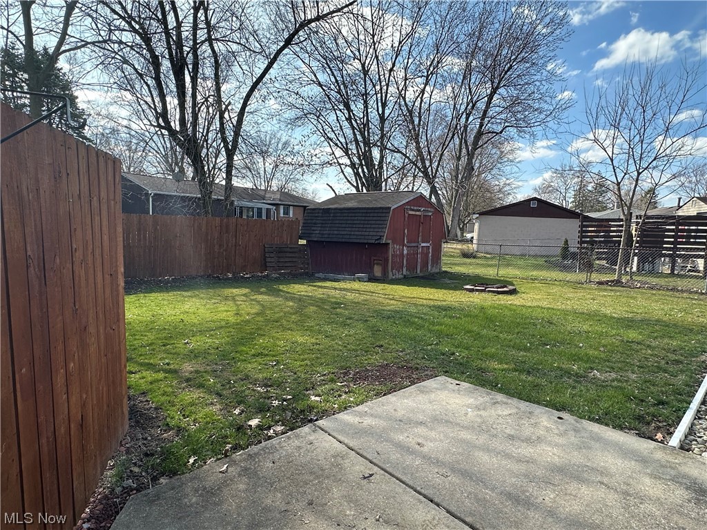 4473 Burkey Road Youngstown, OH 44515 - Photo 23 of 27 View of yard with a patio area, an outdoor fire pit, and a storage shed