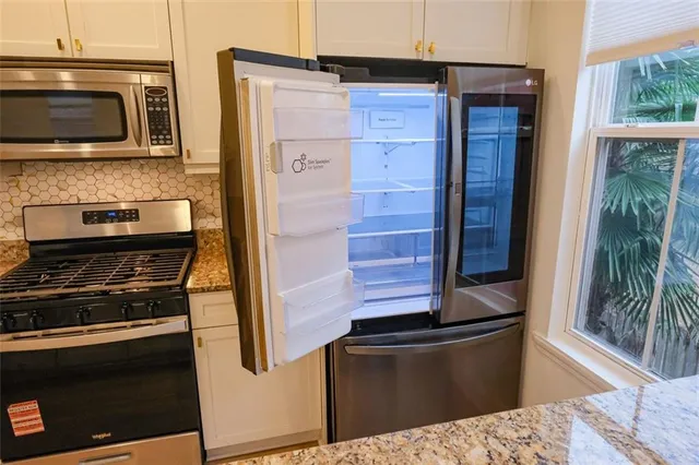 a kitchen with stainless steel appliances kitchen island granite countertop a stove and a microwave