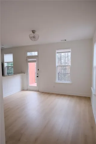 an empty room with windows and chandelier fan