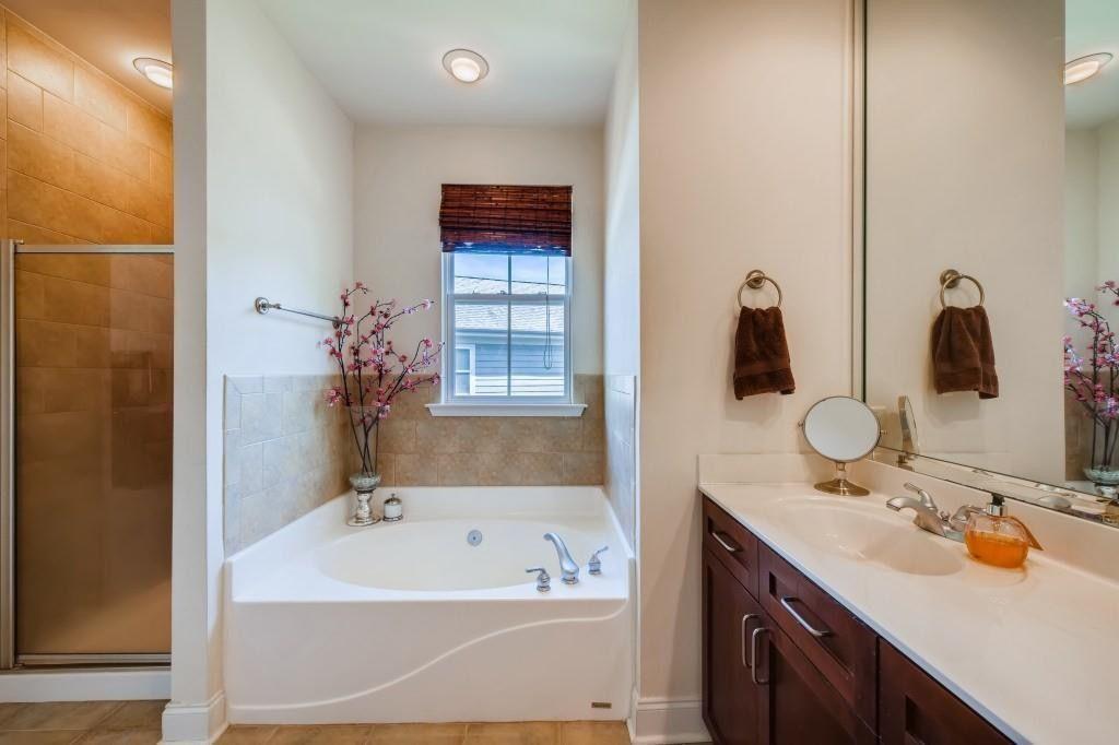 6001 Brookside Oak Circle Norcross, GA 30093 - Photo 18 of 40 a bathroom with a tub sink and mirror