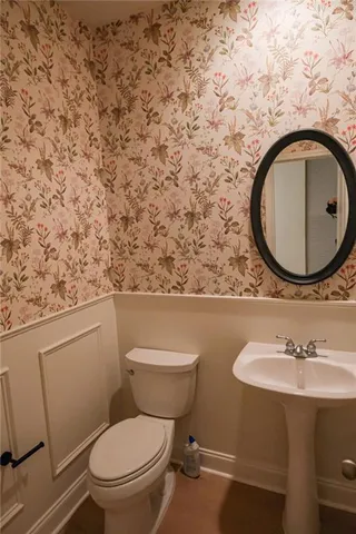 a bathroom with a toilet sink vanity and mirror
