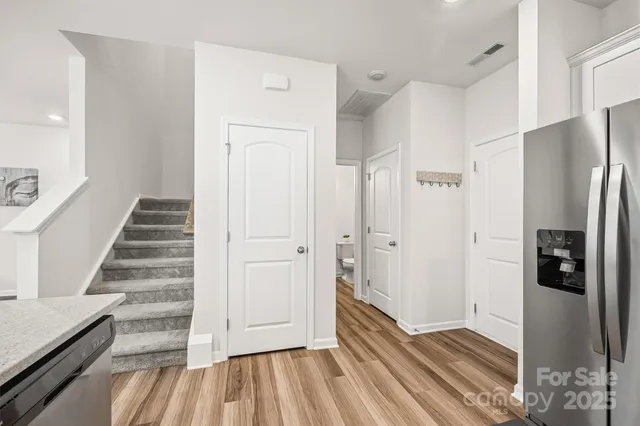 a view of a hallway with wooden floor and staircase