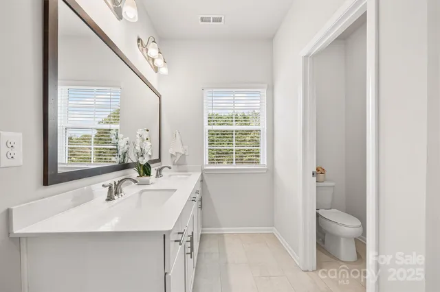 a bathroom with a sink a toilet and a window