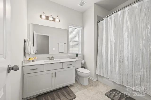a spacious bathroom with a toilet sink and mirror