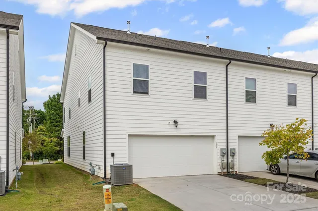 a view of a white house next to a yard