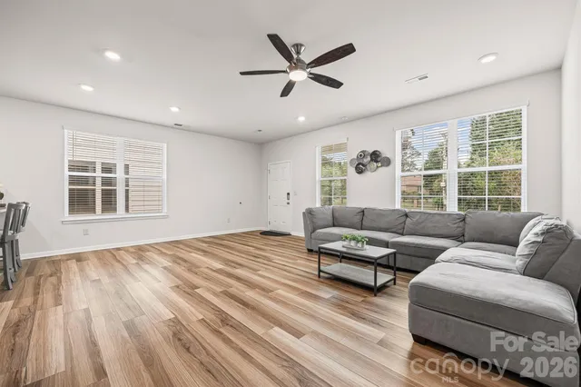 a living room with couches painting on the wall and a large window