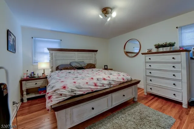 a bedroom with a bed and a lamp on dresser