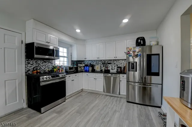 a kitchen with a refrigerator and a stove top oven