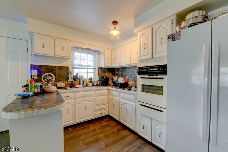 8 Sailer Court Elizabeth, NJ 07201 - Photo 6 of 27 a kitchen with white cabinets and white appliances