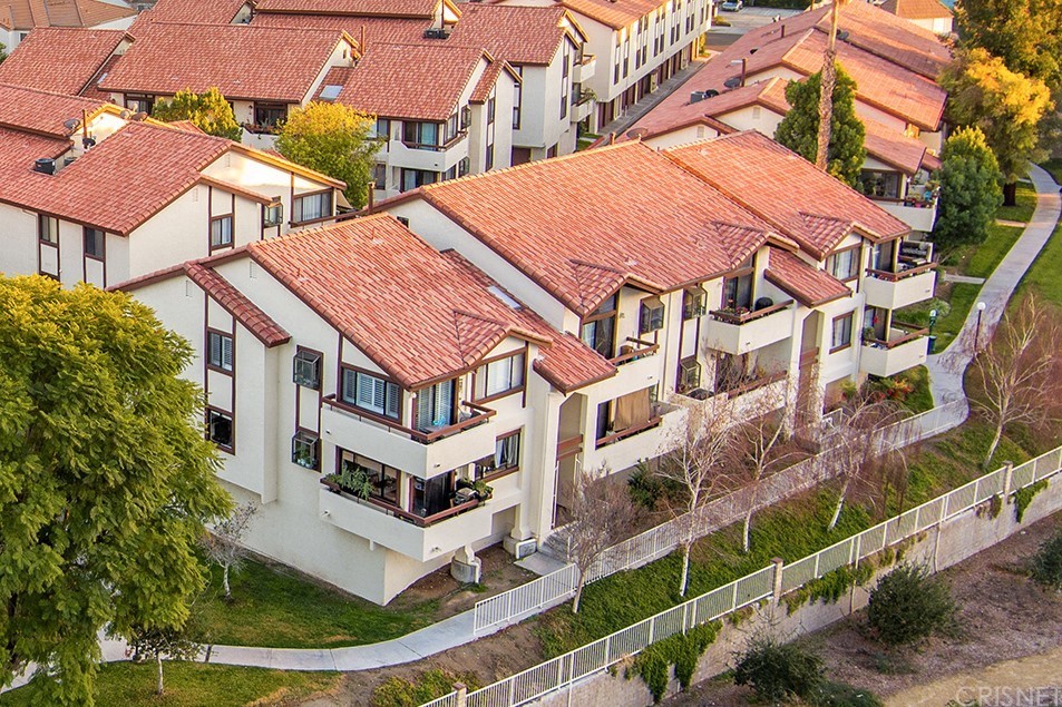 an aerial view of residential houses with yard and trees