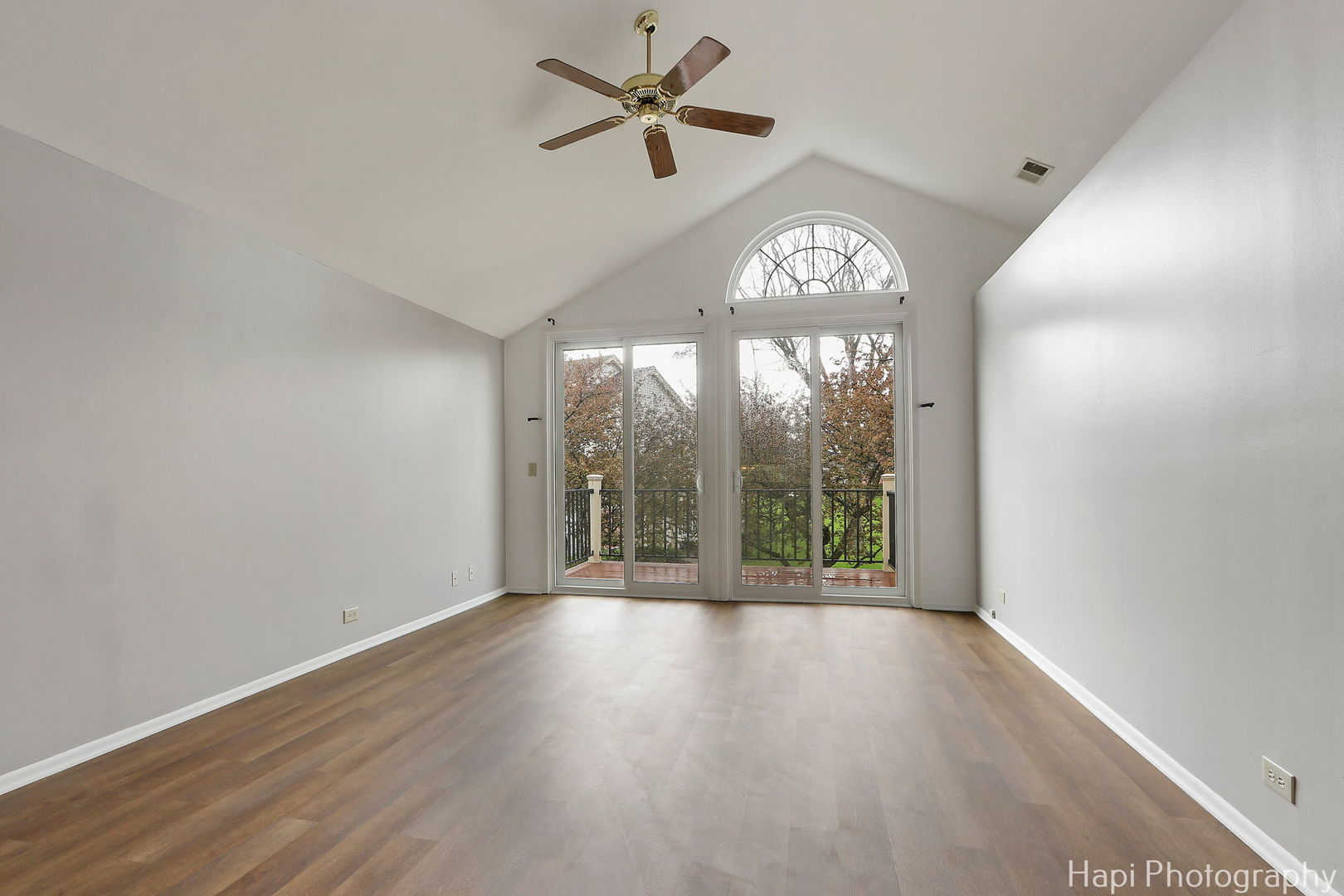 370 Ashford Circle, Unit 2 Bartlett, IL 60103 - Photo 4 of 23 an empty room with wooden floor fan and windows