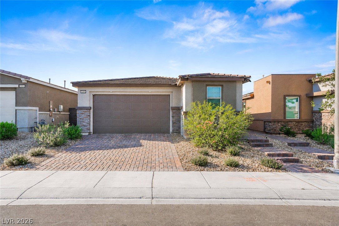 9398 Noble Fir Rdg Court Las Vegas, NV 89143 - Photo 4 of 36 A neatly hardscaped brick paver driveway leads to this charming single-story residence with a desert-friendly front yard.