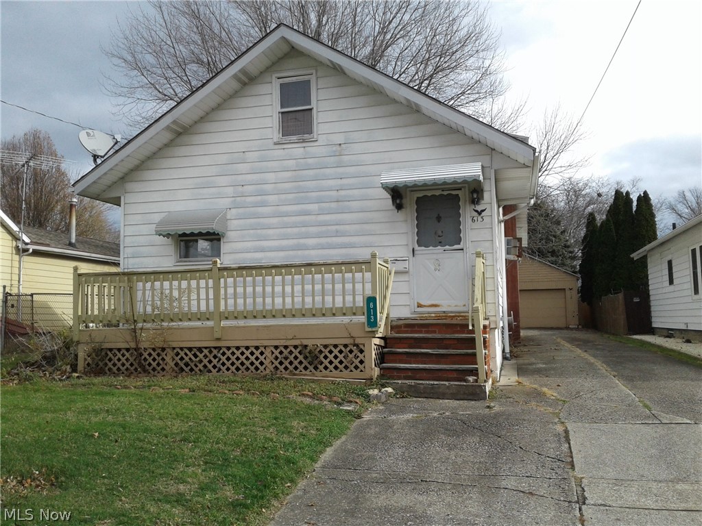 613 Jackson Street Amherst, OH 44001 - Photo 3 of 29 View of front of home featuring a front lawn, a garage, and a deck to the front door into the living room