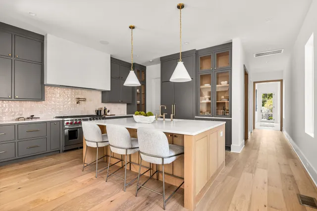 a kitchen with a sink a counter space dining table and stainless steel appliances